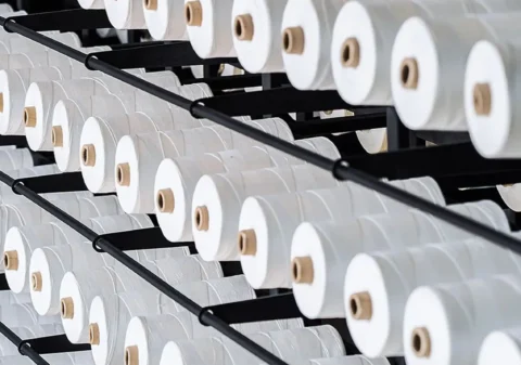 Neatly arranged spools of sewing thread representing the high quality material sourcing by top lingerie manufacturers Appeals to clients seeking wholesale womens lingerie highlighting the commitment to using the best materials in production