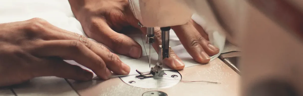 hands operating a sewing machine, highlighting the craftsmanship involved in creating women's lingerie. Demonstrates the skill of lingerie manufacturers in producing custom and OEM womens lingerie with precision.