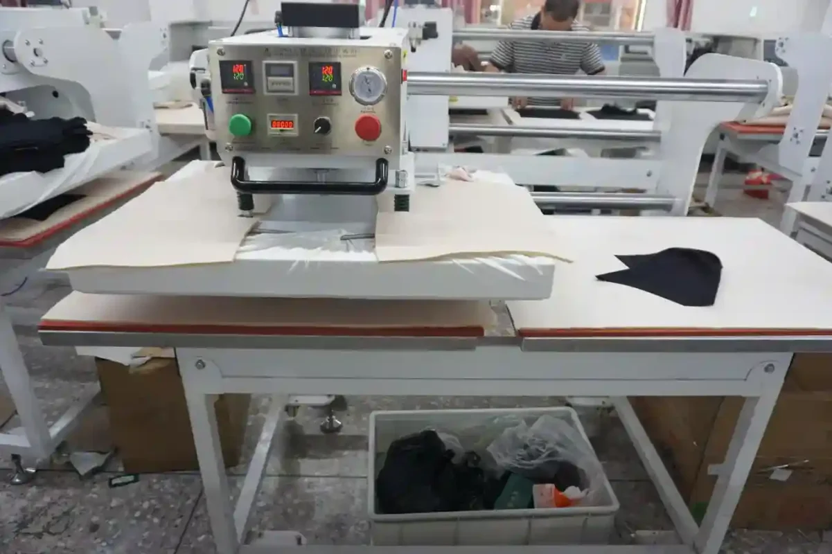 Industrial equipment in a factory setting with fabric pieces on the worktable showcasing the machinery used by underwear suppliers and vendors in production