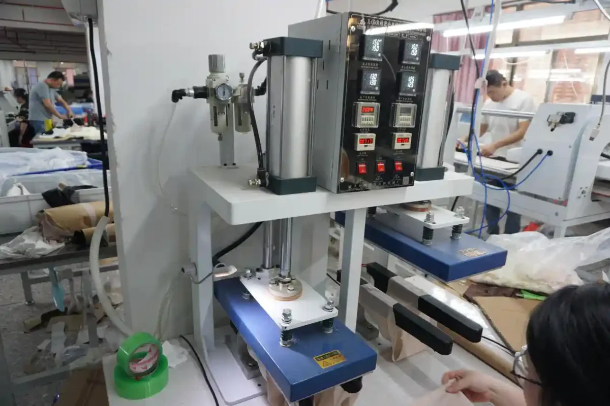 An industrial machine in a busy factory workshop surrounded by workers and production materials highlighting the manufacturing processes of underwear suppliers and vendors