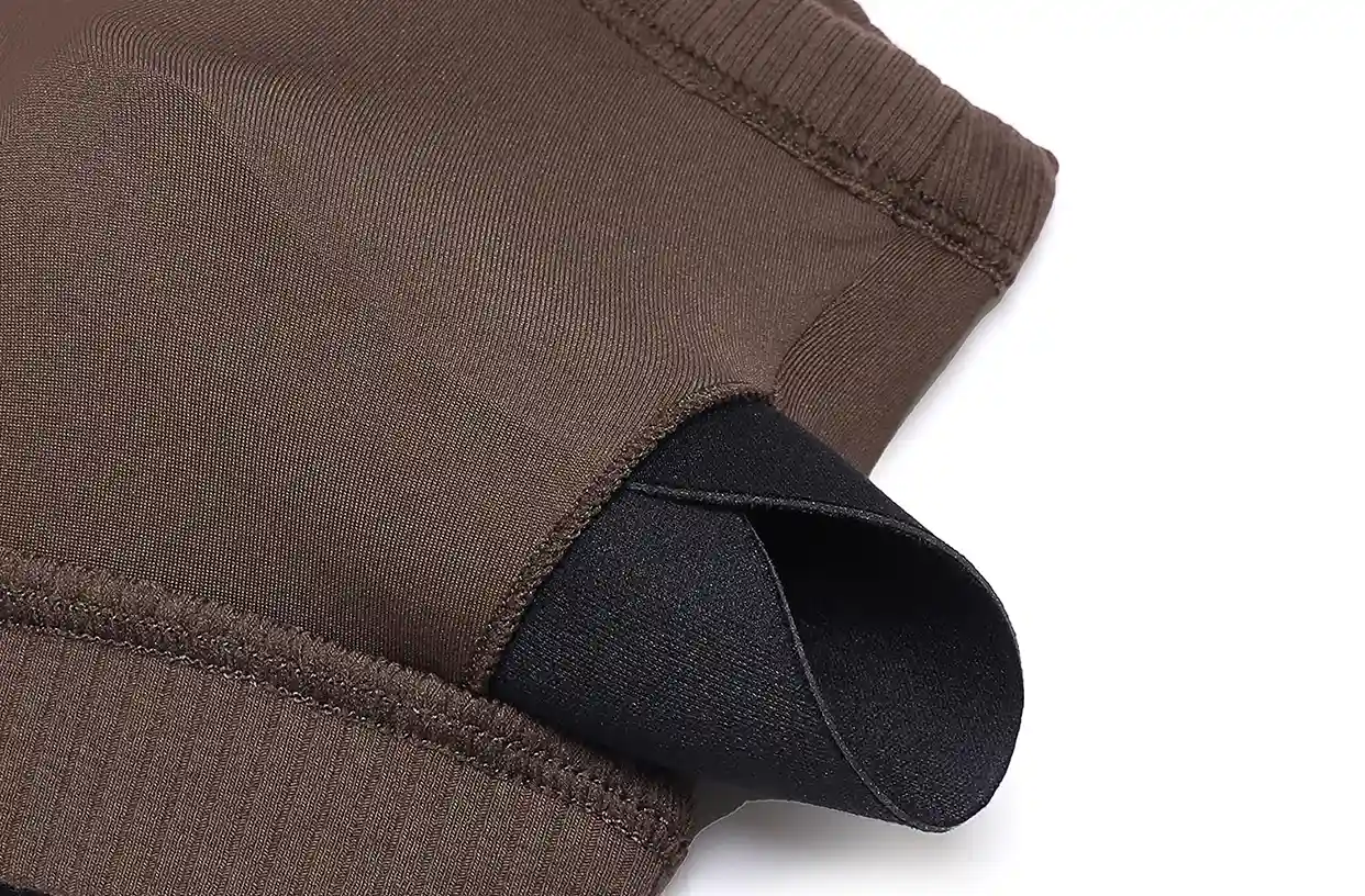 Ribbed Sports Bras Wireless Lightweight Stretchy15 zoralinkcom Close up of a brown ribbed fabric with a folded edge revealing a black inner layer highlighting the materials texture and construction
