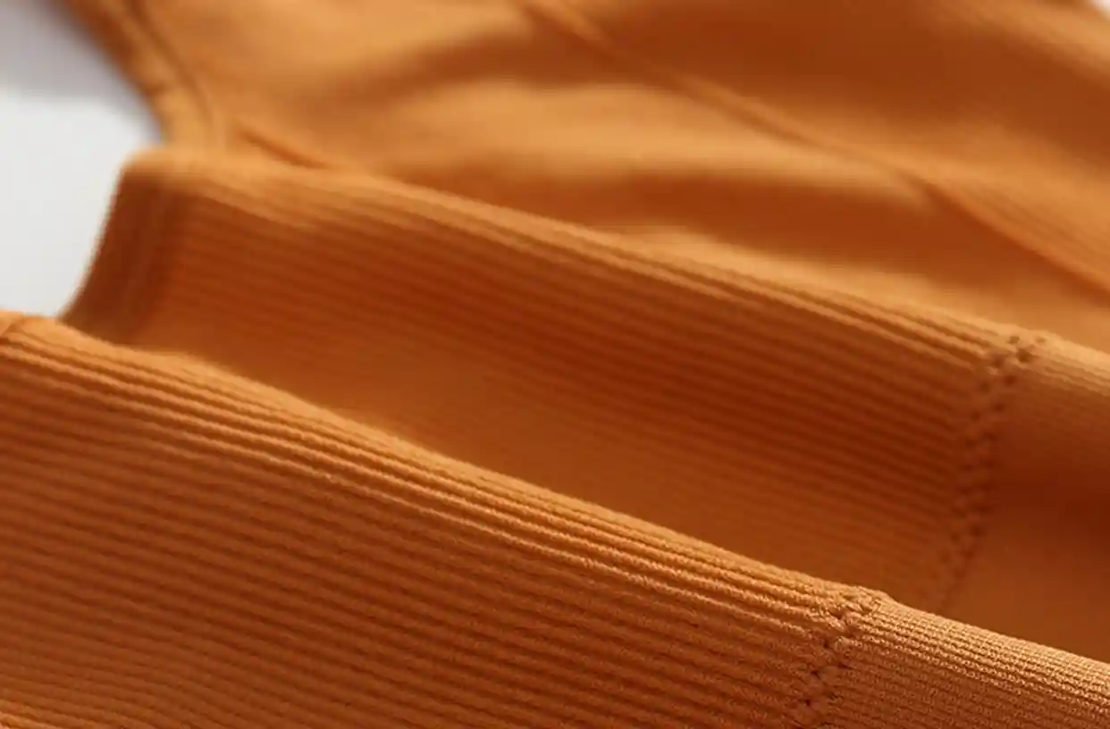 Square Collar Sports Bra10 zoralinkcom Close up of orange seamless sports bra fabric featuring breathability and moisture wicking technology for fitness activities