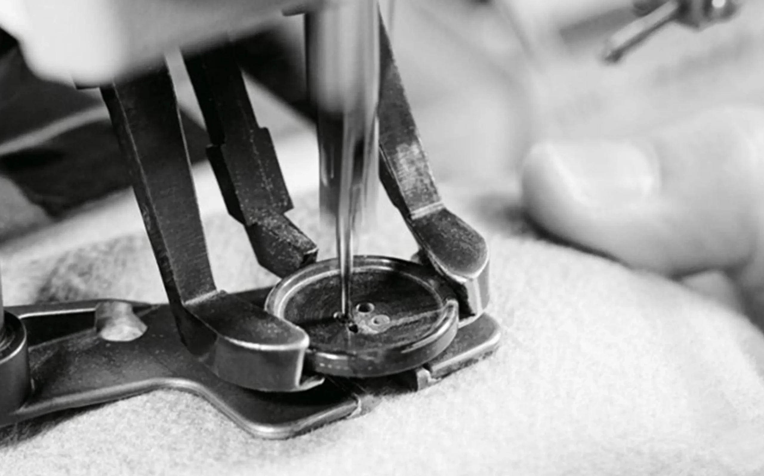 Wholesale Lingerie Manufacturers vs Distributors zoralinkcom Close up of a sewing machine attaching a button to fabric representing meticulous craftsmanship in lingerie manufacturing Symbolizes a lingerie manufacturers commitment to quality appealing to clients seeking wholesale womens lingerie with attention to detail