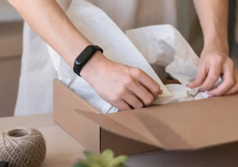 Hands carefully packaging lingerie showcasing the attention to detail by lingerie manufacturers Ideal for custom cut and sew orders with low MOQ ensuring a delicate unboxing experience for every piece